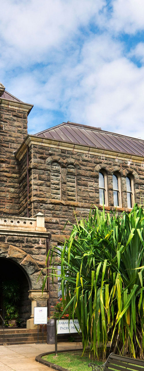 Historic stone building with lush greenery