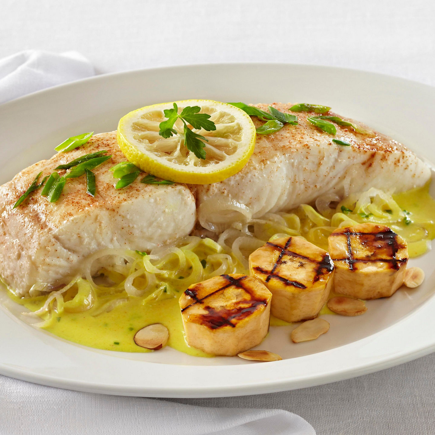 Grilled fish with lemon garnish and sides