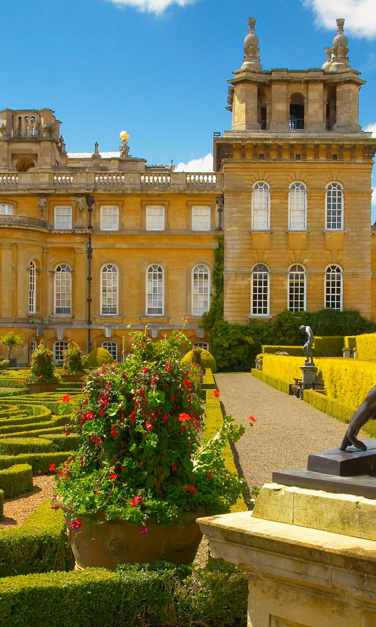 Historic palace with ornate gardens and statue