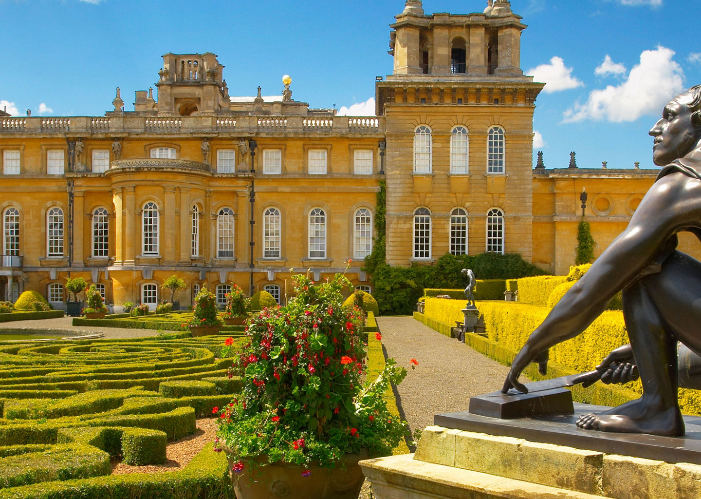 Historic palace with ornate gardens and statue