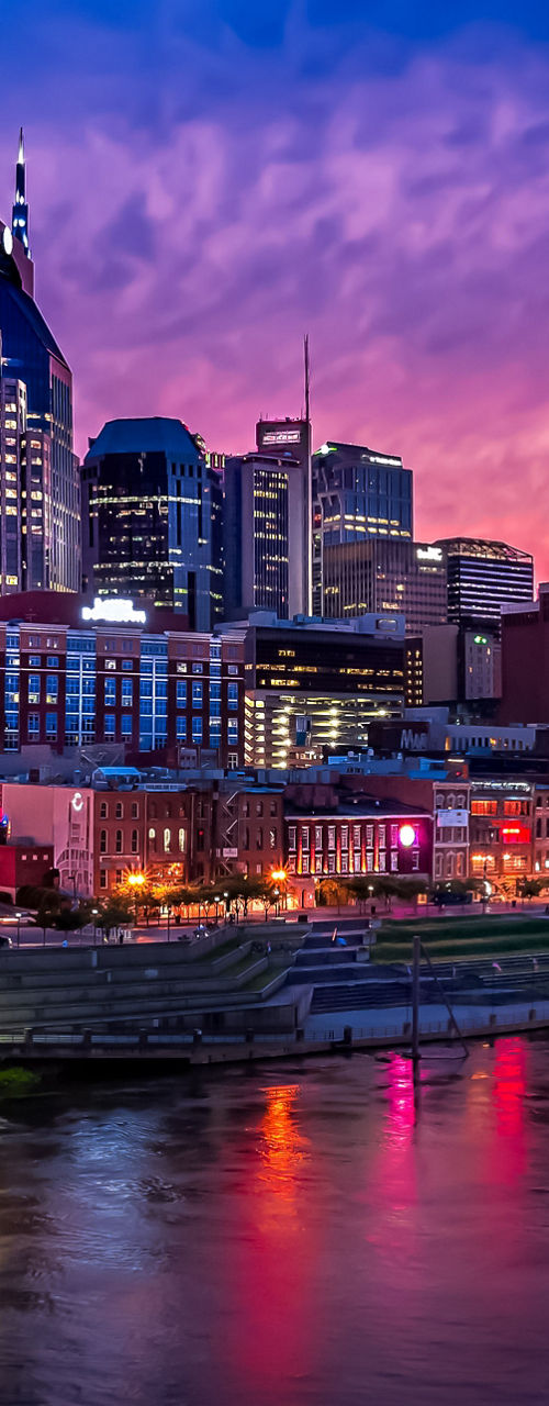 Vibrant City Skyline at Dusk with River Reflections