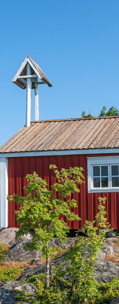 Red cabin with lighthouse in rocky landscape