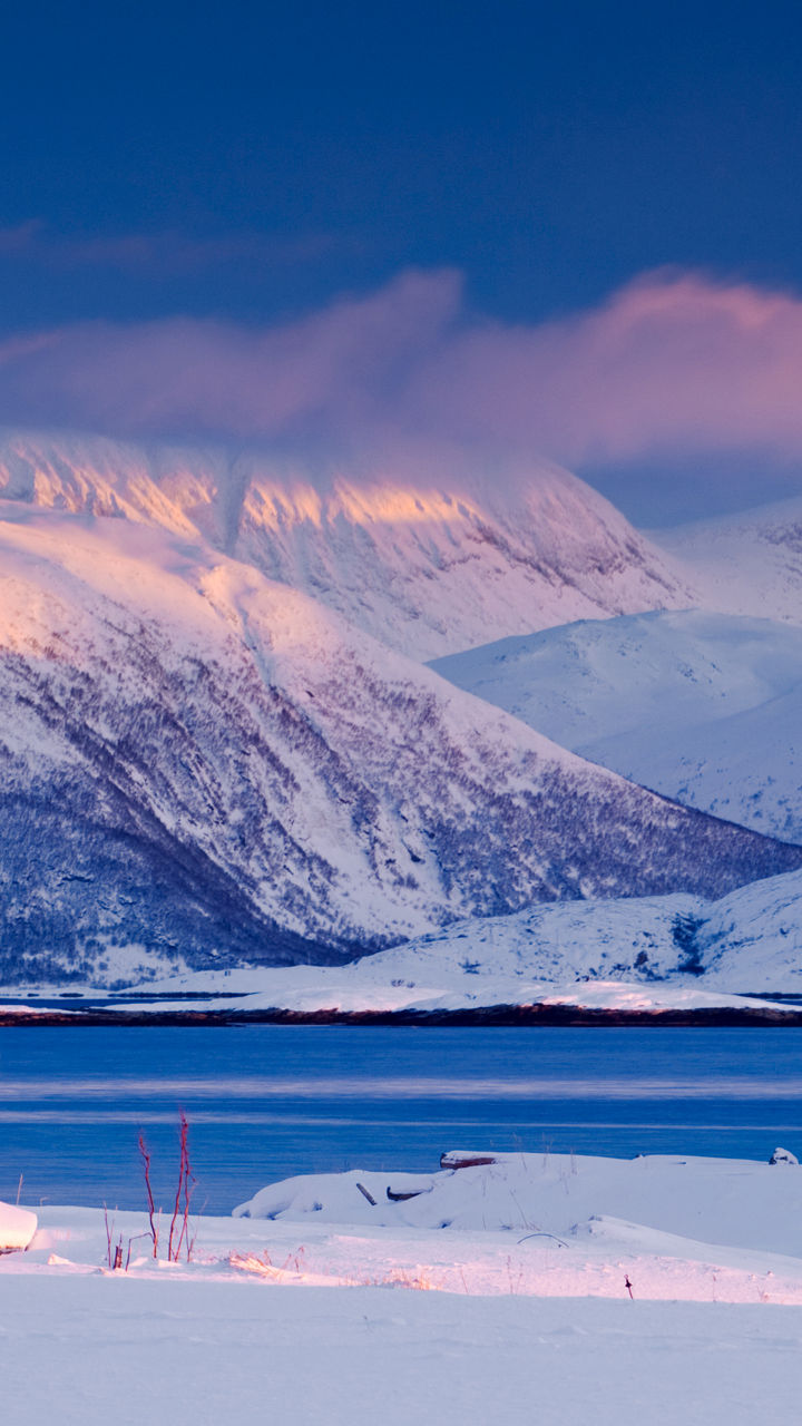 Red cabin in snowy mountain landscape