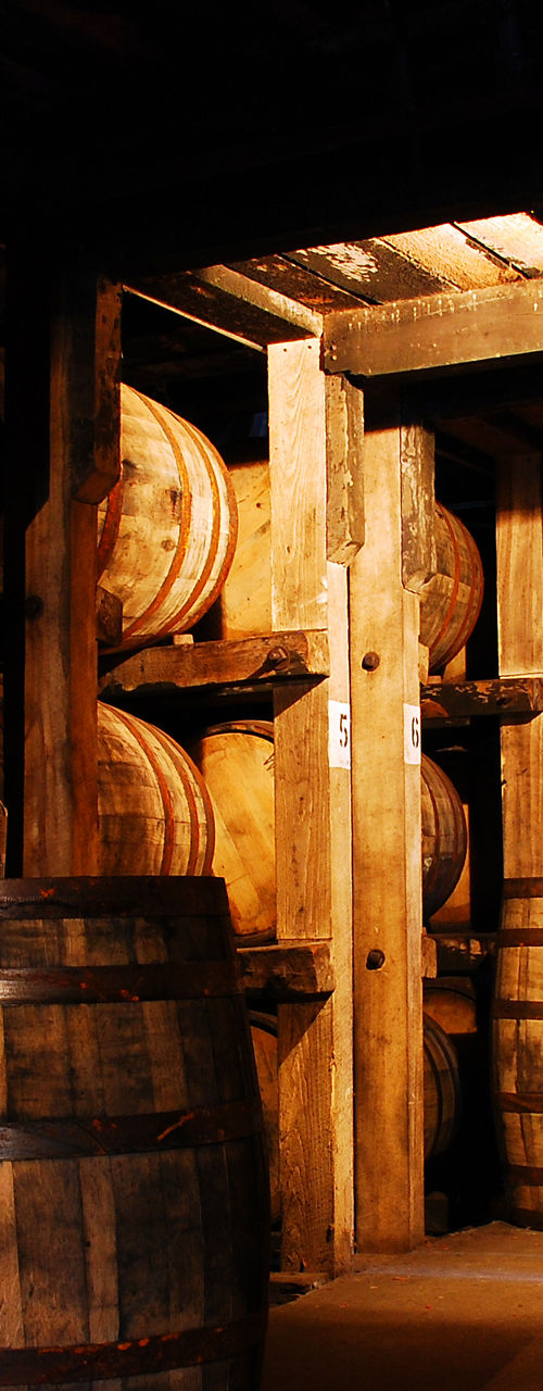 Rustic whiskey barrel storage in wooden cellar