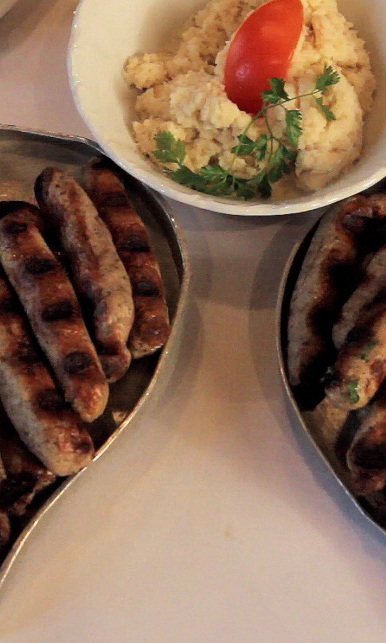 Grilled sausages with sides on plates