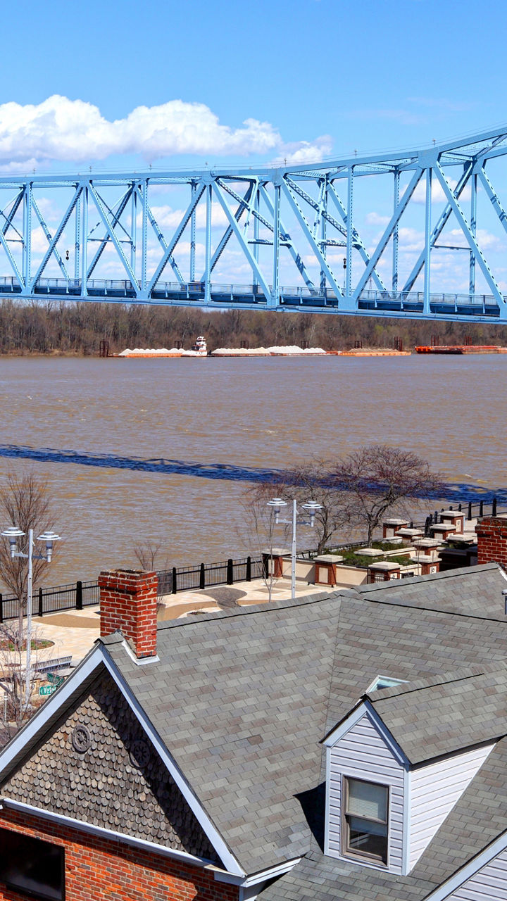 Blue bridge over river with urban buildings