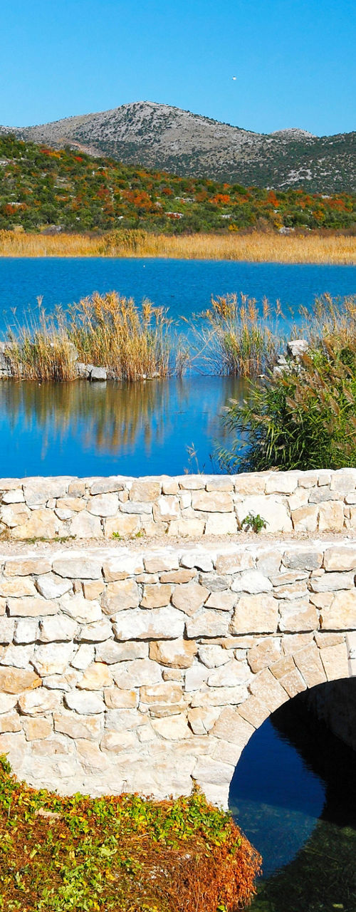 Stone bridge over calm blue lake