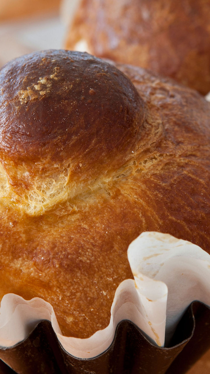 Golden brioche buns on orange tablecloth