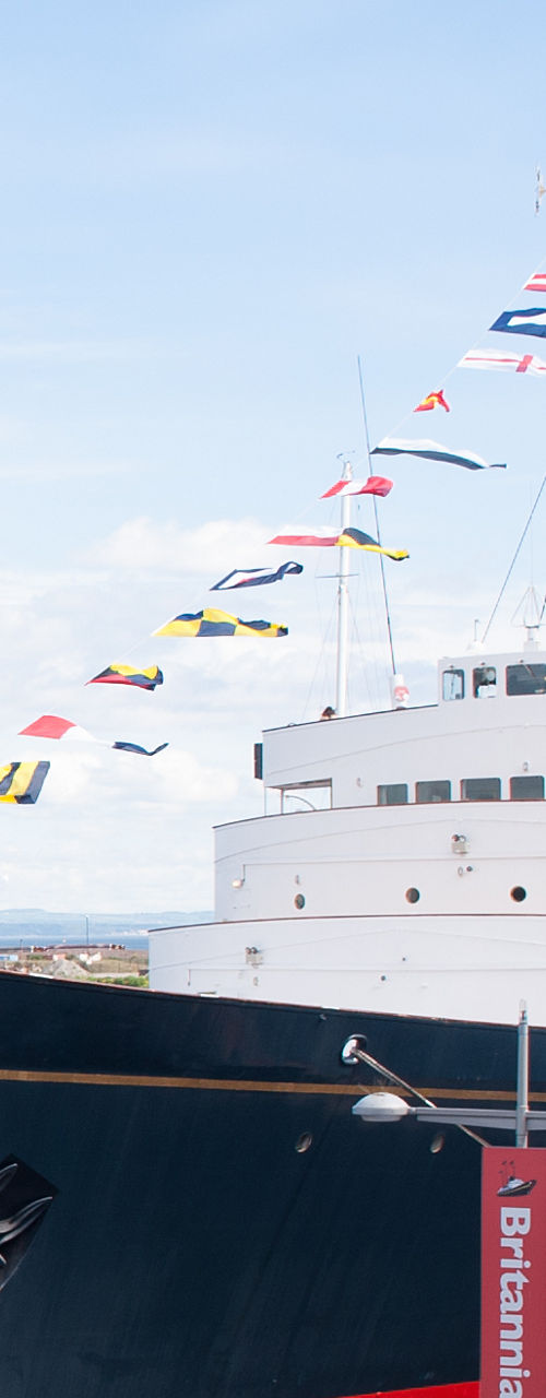 Royal yacht docked with flags displayed