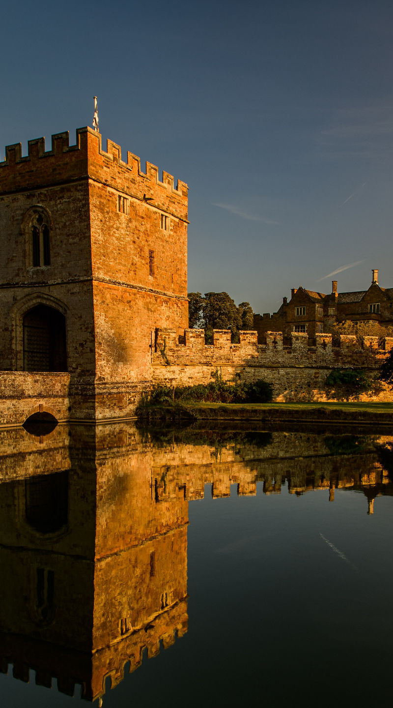 Historic castle with moat at sunset