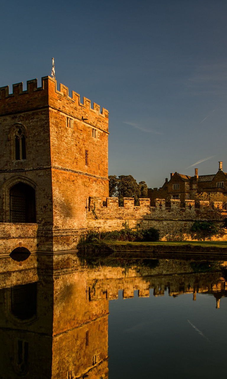 Historic castle with moat at sunset