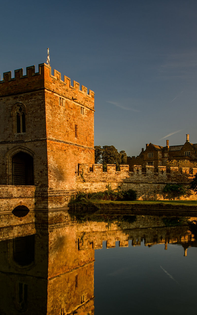 Historic castle with moat at sunset
