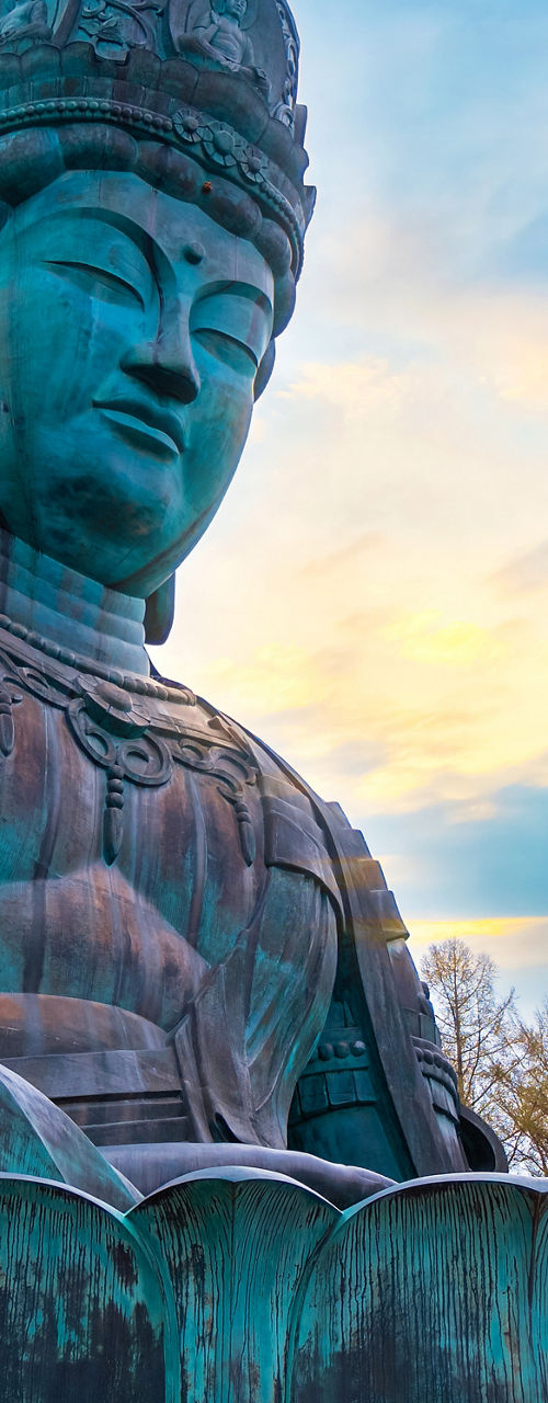 Large bronze Buddha statue at sunset outdoors