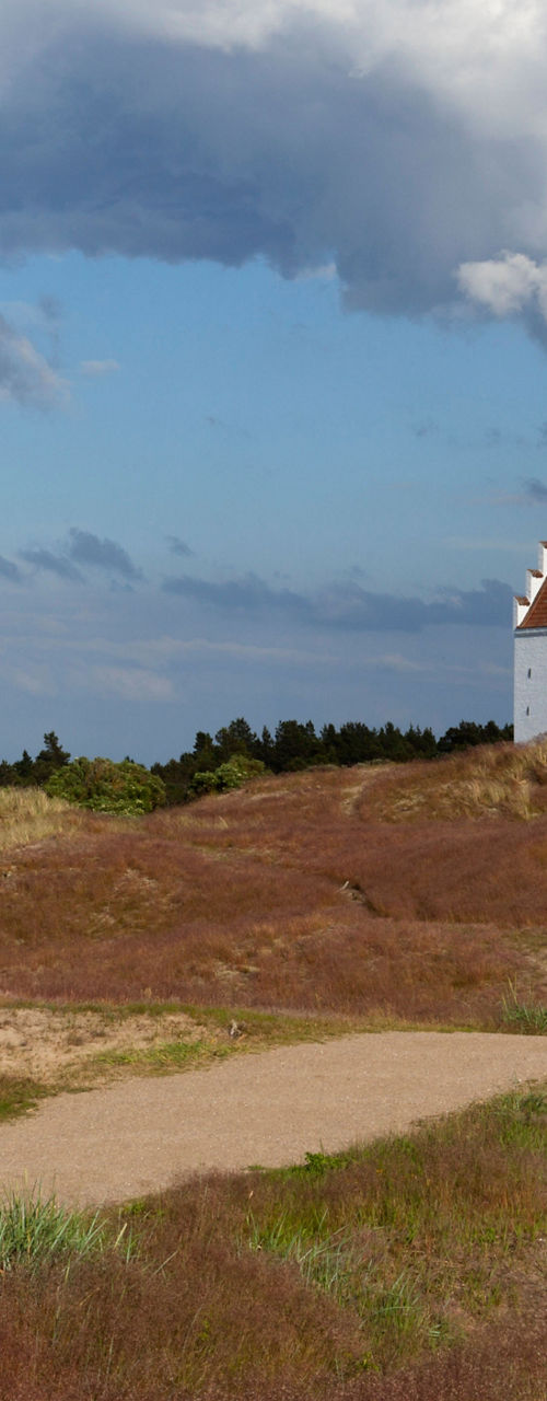 Cyclist near white church in scenic dunes