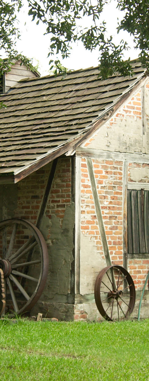 Historic Brick Cabin with Wooden Fence and Wagon Wheels