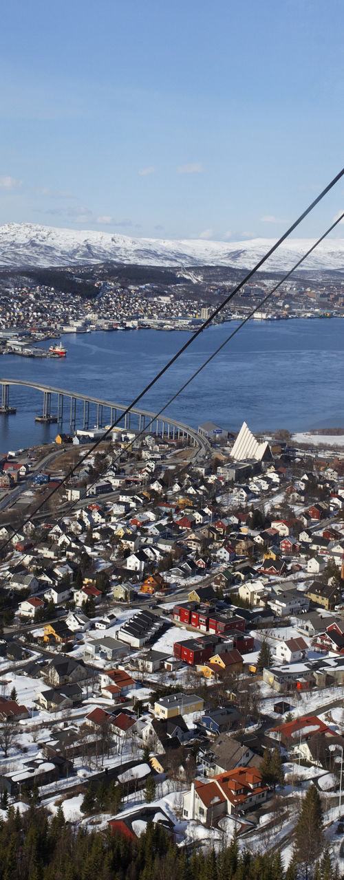 Red cable car overlooking snowy cityscape