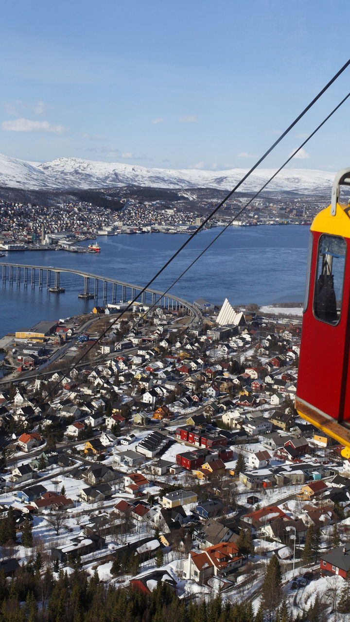 Red cable car overlooking snowy cityscape