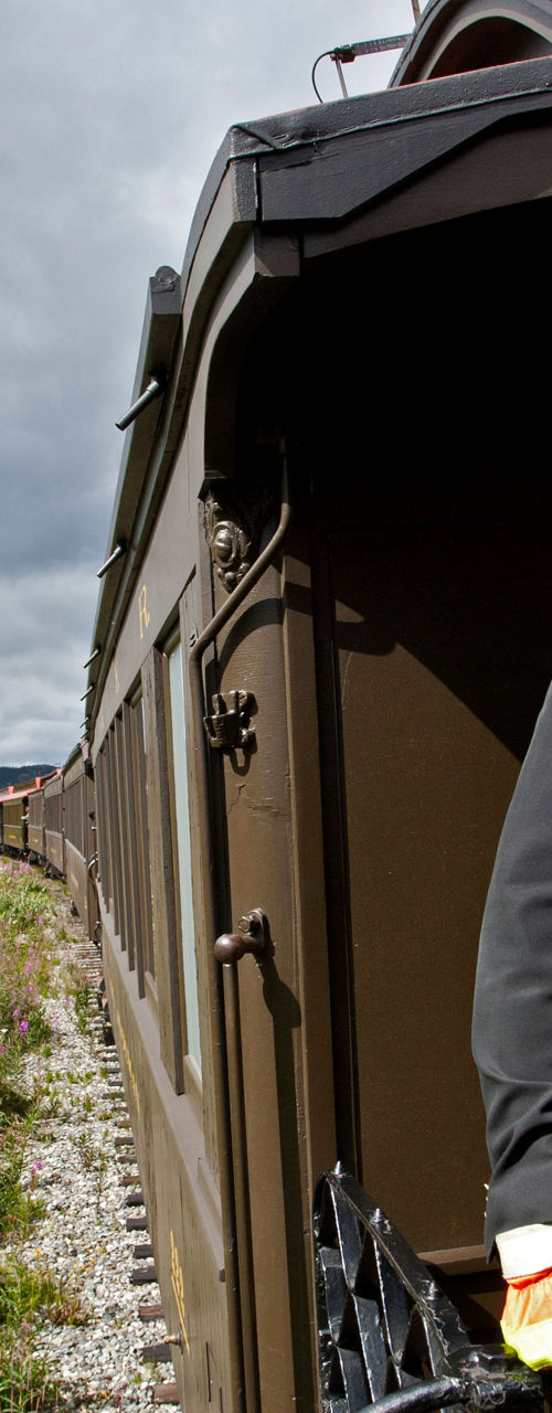 Train conductor on vintage railcar