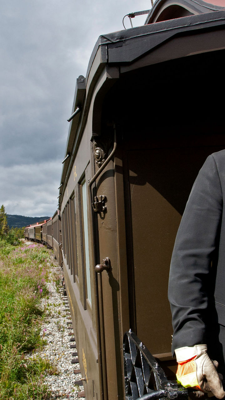 Train conductor on vintage railcar