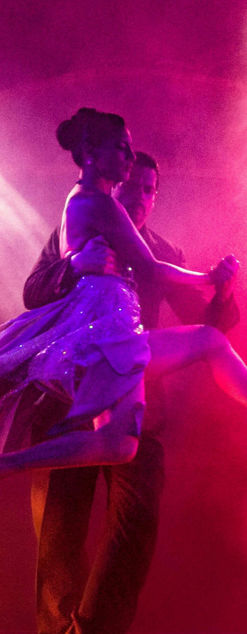 Couple dancing under vibrant stage lights