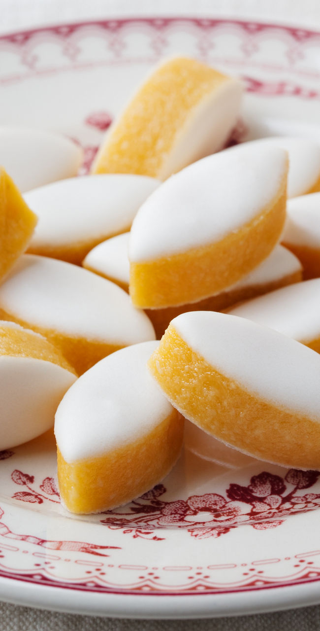 Plate of glazed almond cookies on table