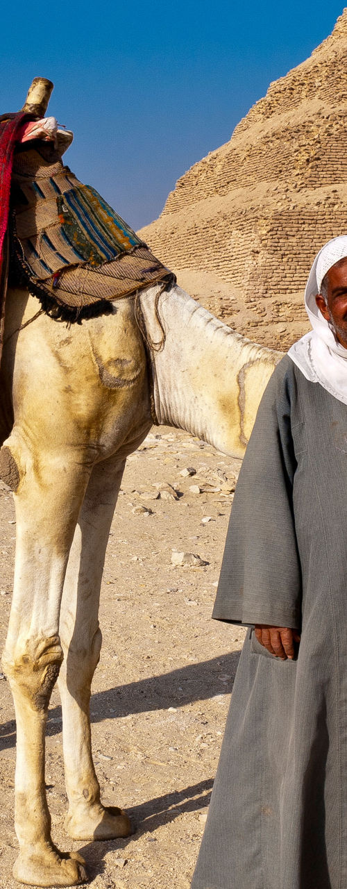 Camel and handler near ancient pyramid