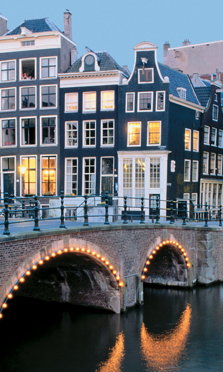 Scenic Amsterdam canal with illuminated bridges