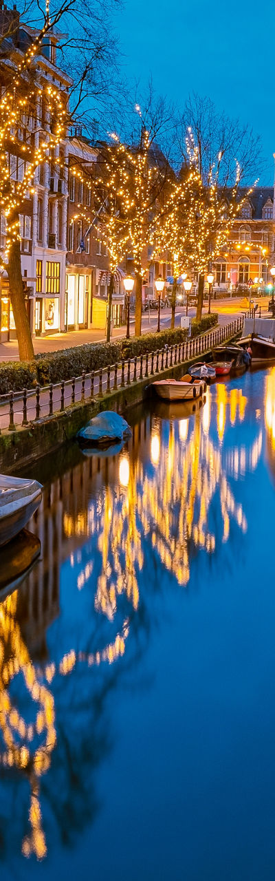Illuminated canal in Amsterdam at dusk