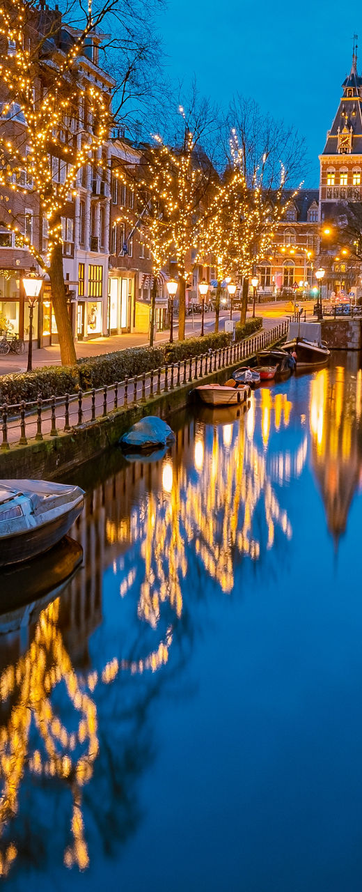 Illuminated canal in Amsterdam at dusk