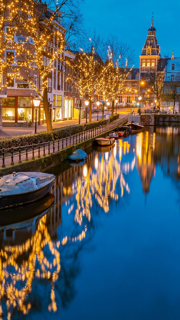 Illuminated canal in Amsterdam at dusk