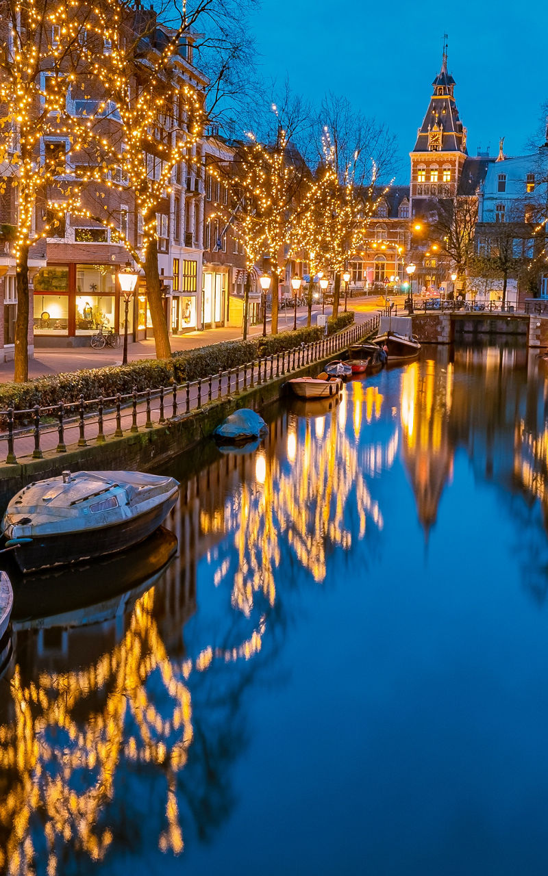 Illuminated canal in Amsterdam at dusk