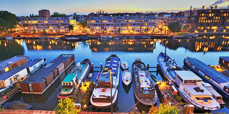 Scenic canal with boats at sunset