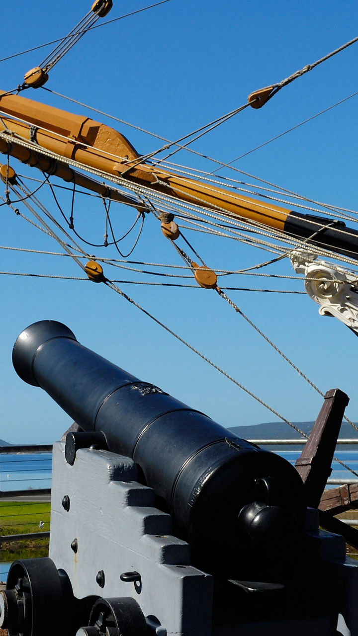 Historic ship with cannon by waterfront