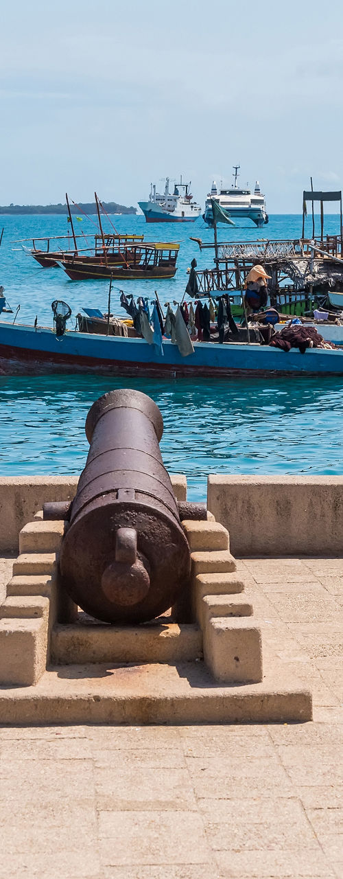 Historic cannons overlooking ocean with boats