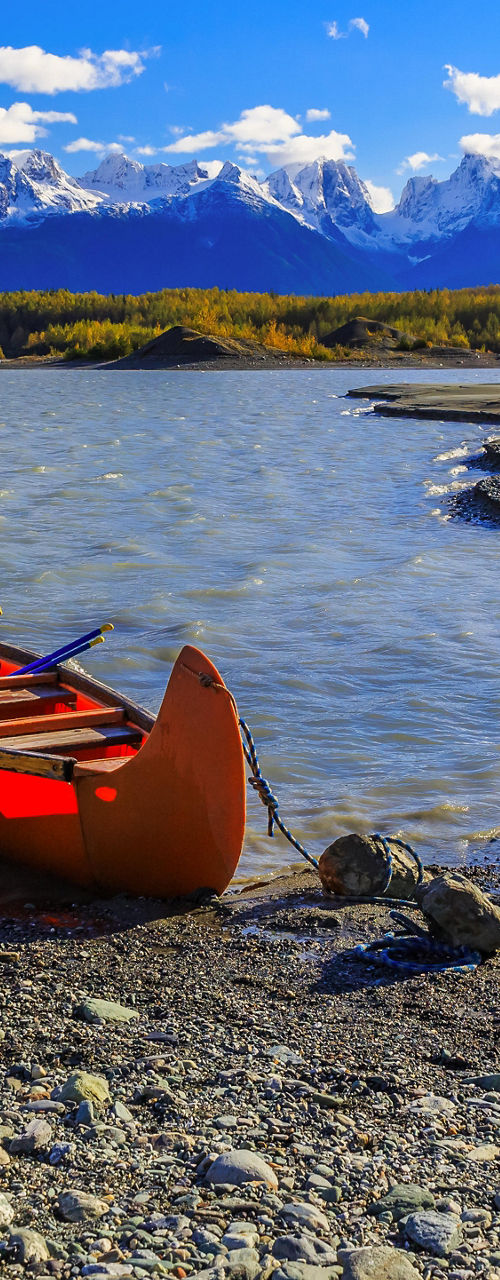 Red canoe on scenic mountain lake shore