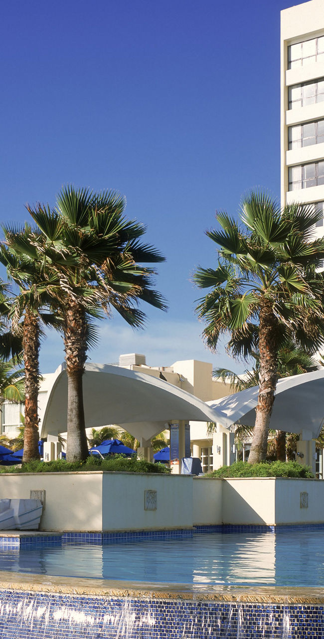 Modern hotel with pool and palm trees
