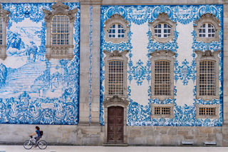 Cyclist passing ornate blue tile facade