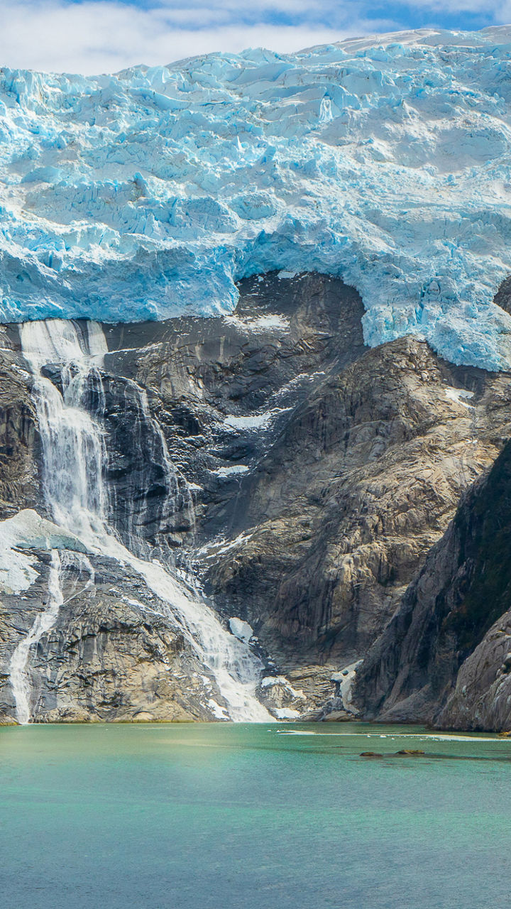 Majestic glacier waterfall in serene landscape