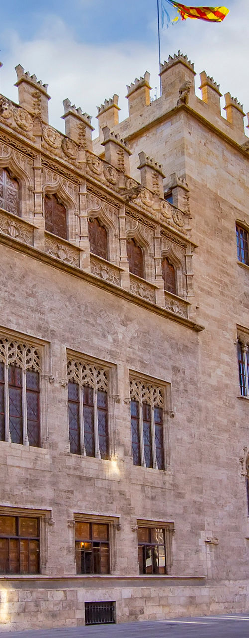 Historic stone building with Spanish flag