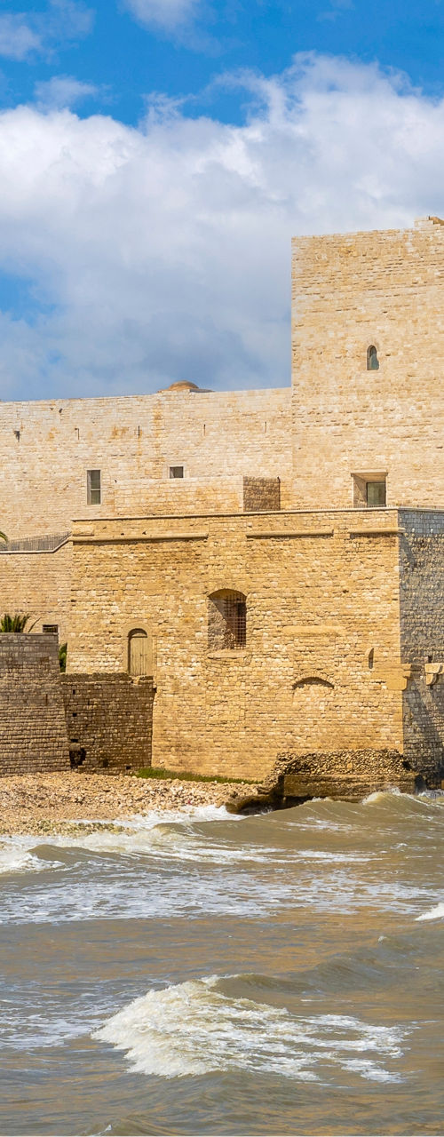 Historic coastal castle under blue skies