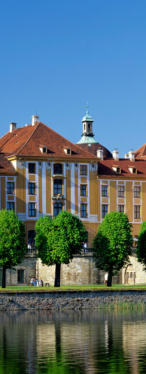 Baroque castle reflected in serene lake