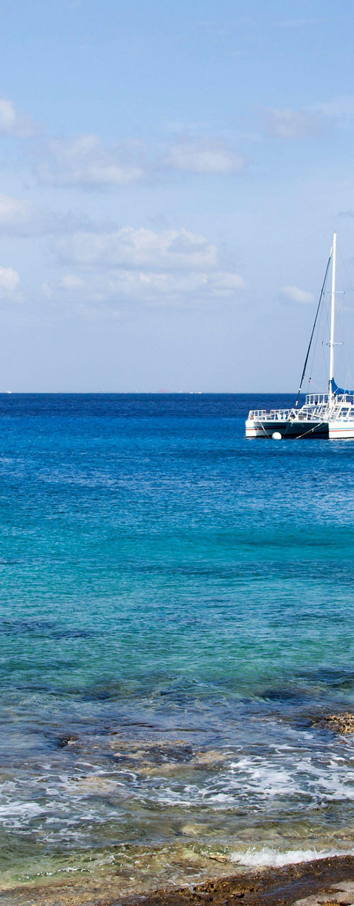 Catamaran sailing on clear blue tropical sea