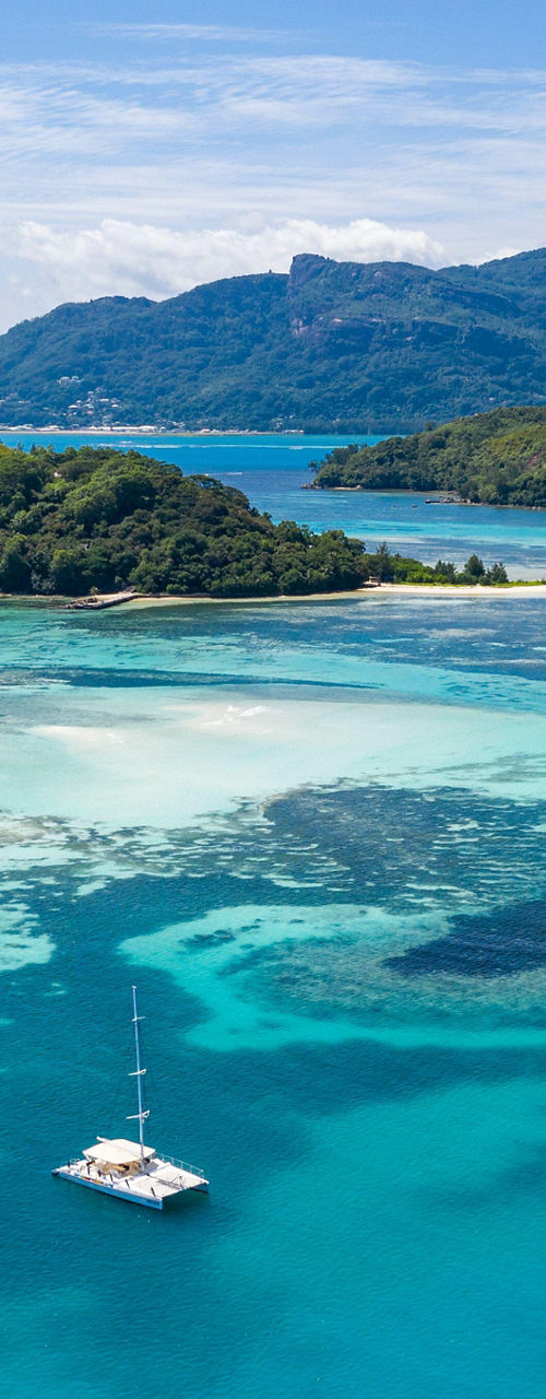 Tropical island with turquoise waters and yacht