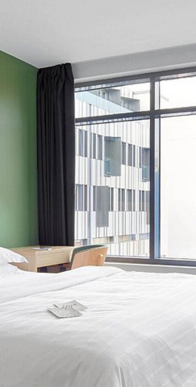 Modern hotel room with green accent wall
