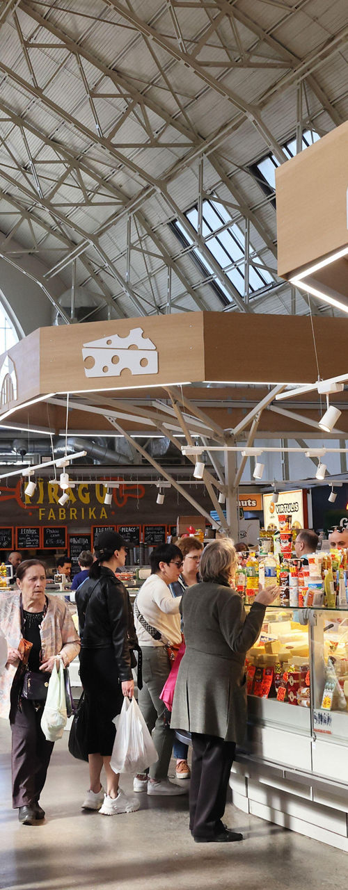 Busy indoor market hall with food stalls and shoppers