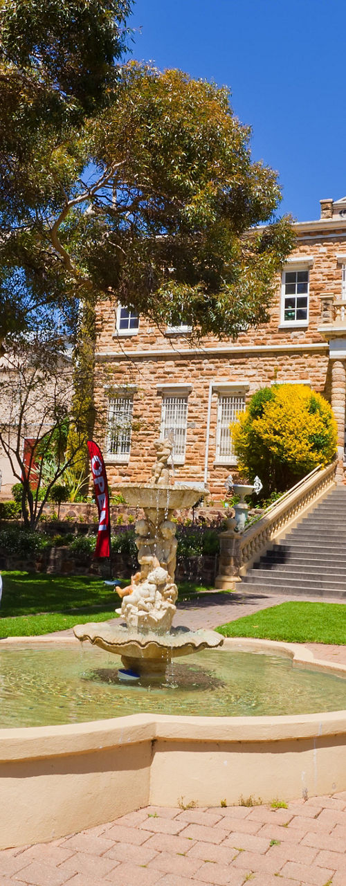 Historic stone building with garden fountain