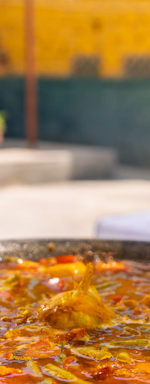 Chef adding rice to outdoor paella