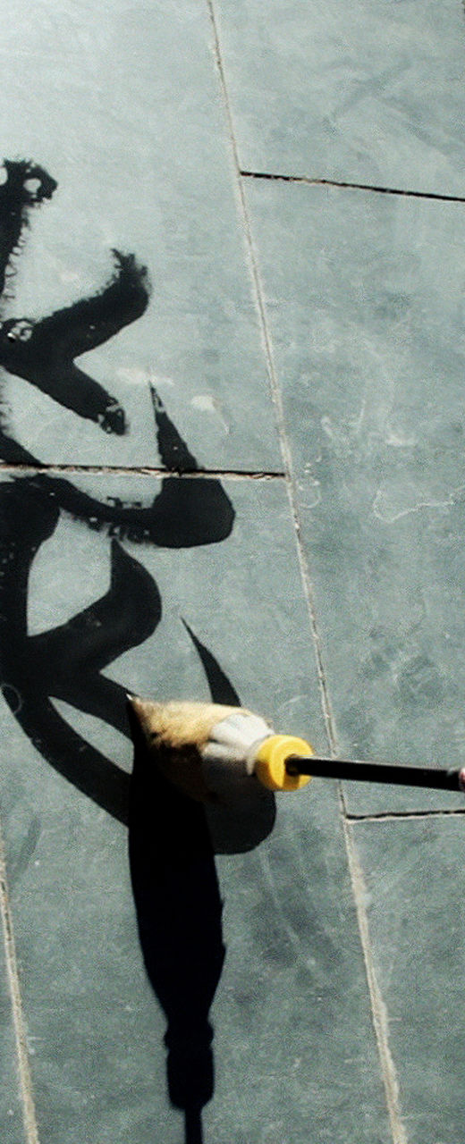 Water calligraphy on tiled pavement