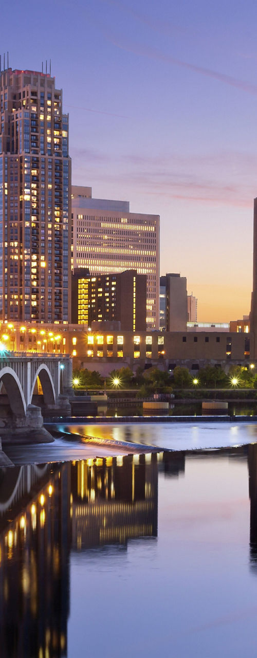 Minneapolis skyline at dusk with bridge reflection