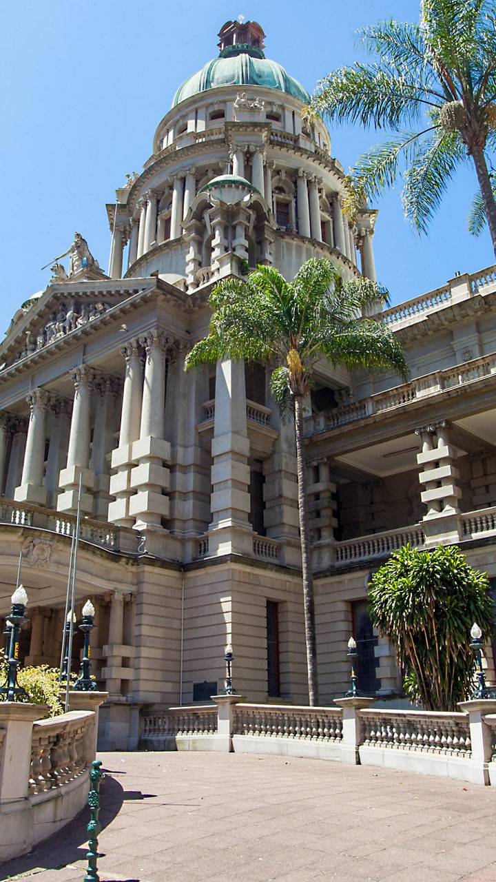 Historic building with palm trees in sunlight